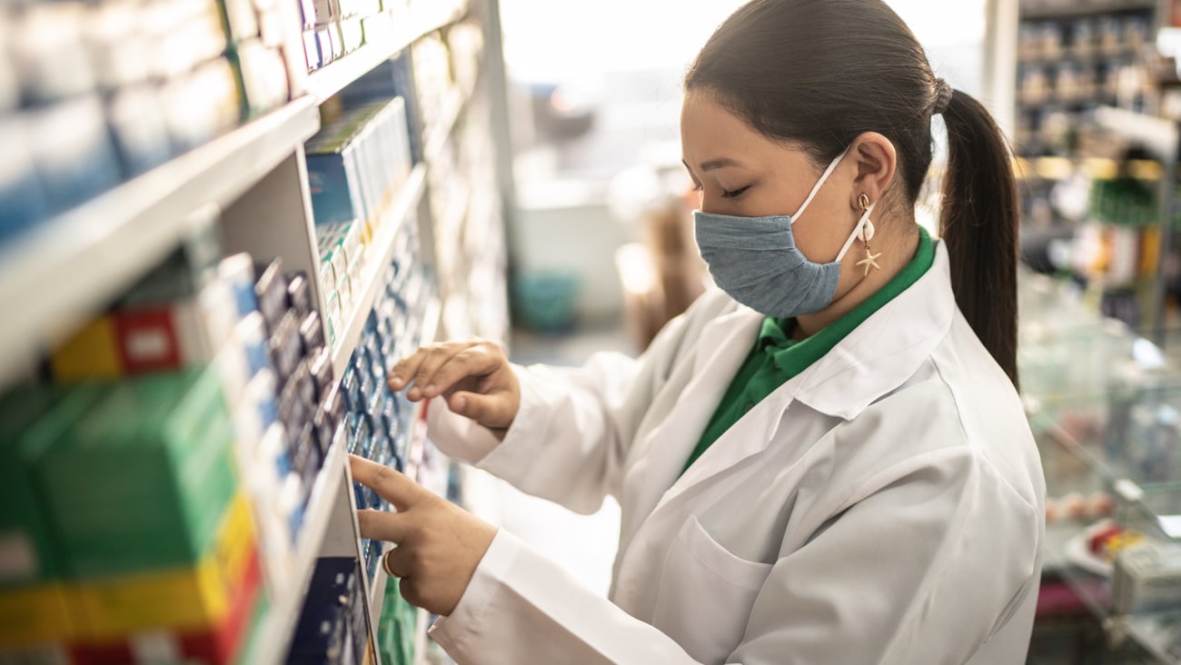 une pharmacienne range des boîtes de médicaments