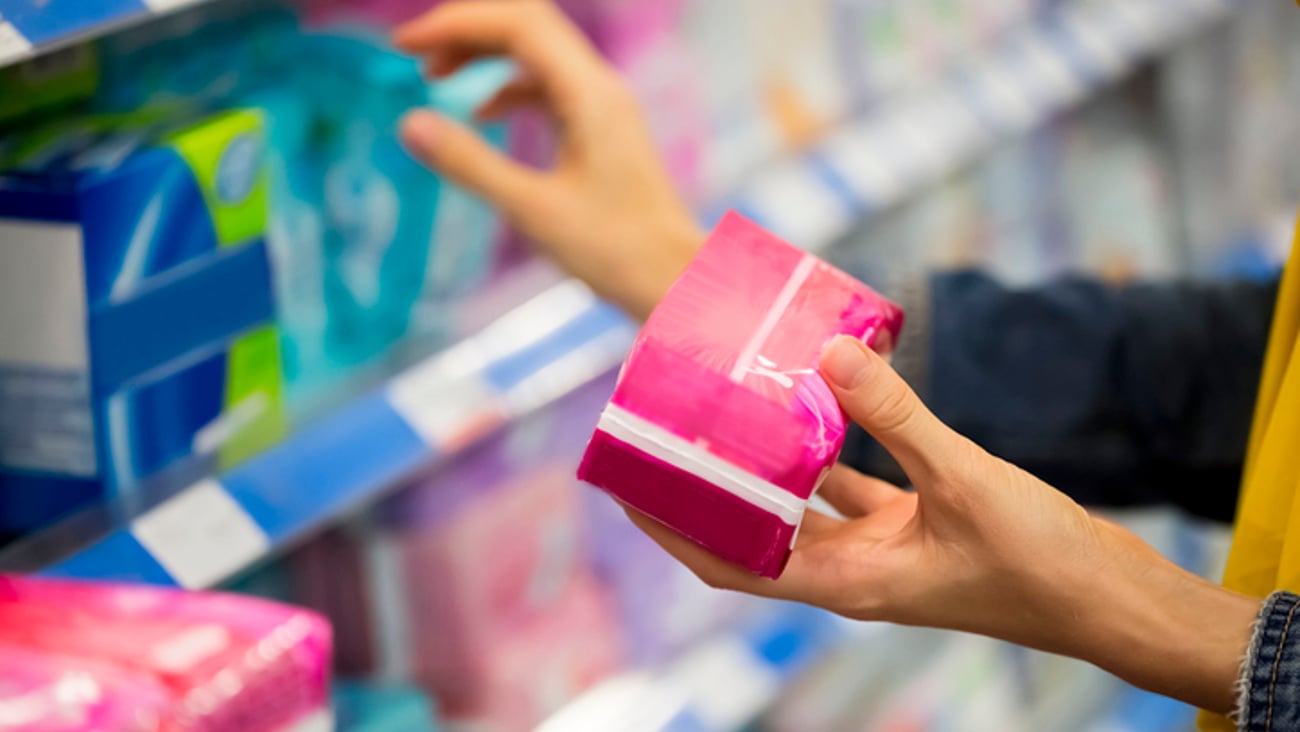 Une femme magasine des produits menstruels.