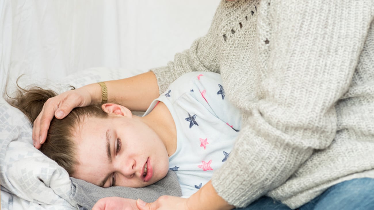 Un enfant souffrant d’épilepsie durant une crise est rassurée par sa mère.