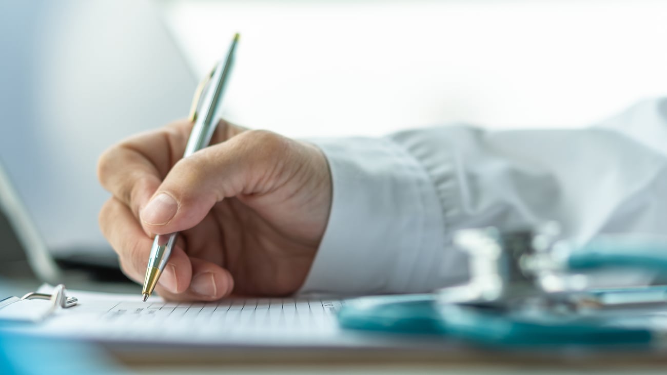 Usurpation d'identité - main d'un médecin tenant un stylo