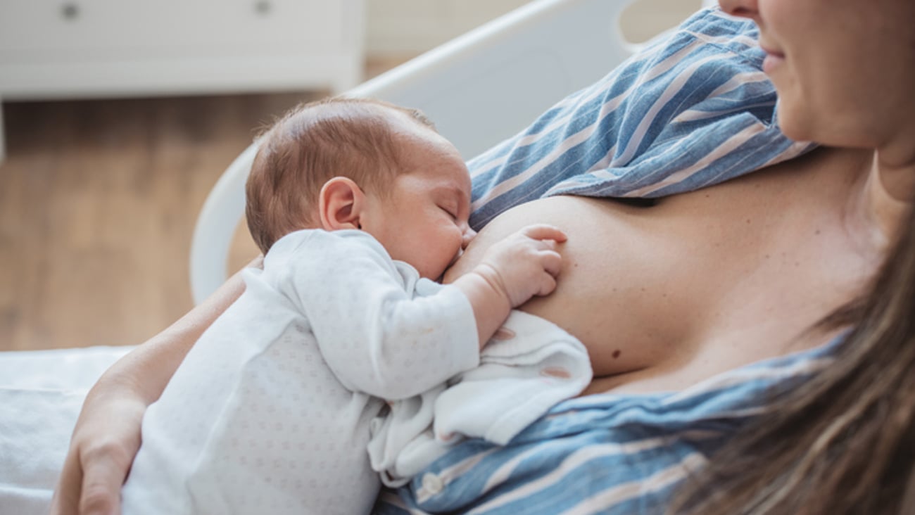 Une femme allaite son bébé à l'hôpital.