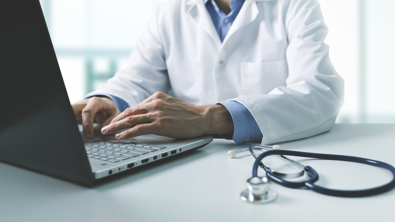 Médecin en train de travailler sur son ordinateur portable.