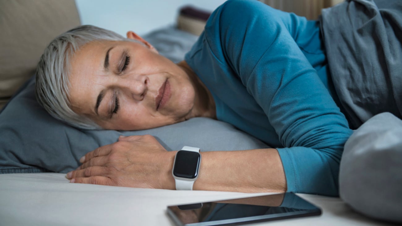 Une femme porte une montre dotée d'une application de suivi du sommeil.