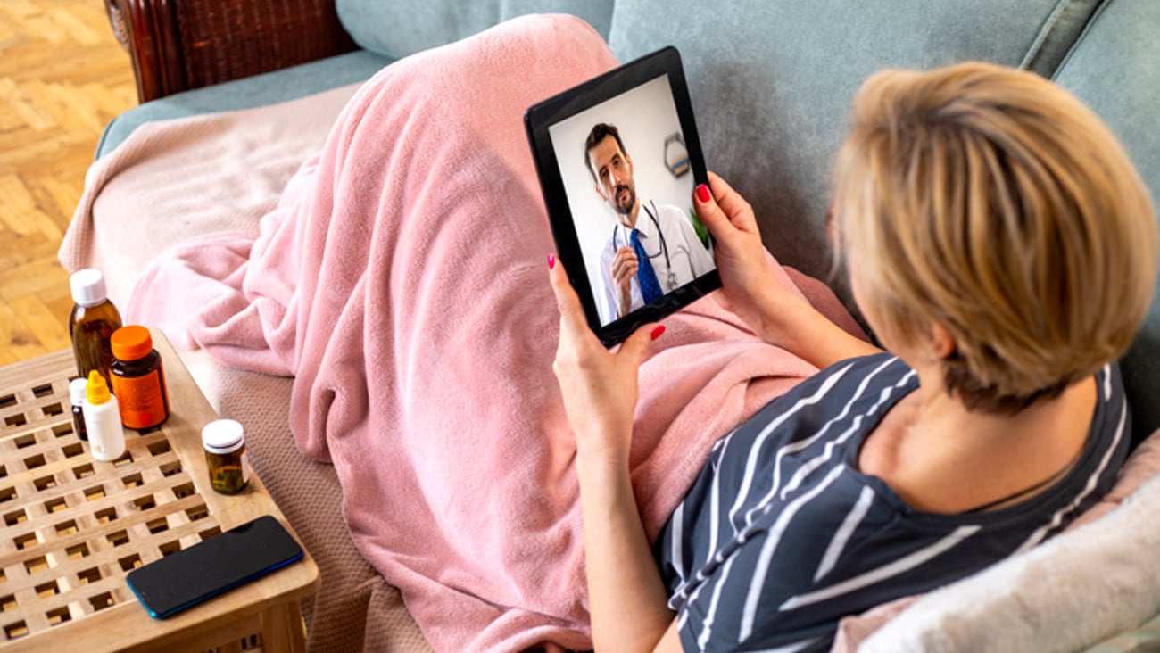 Une femme en téléconsultation avec son médecin grâce à sa tablette.