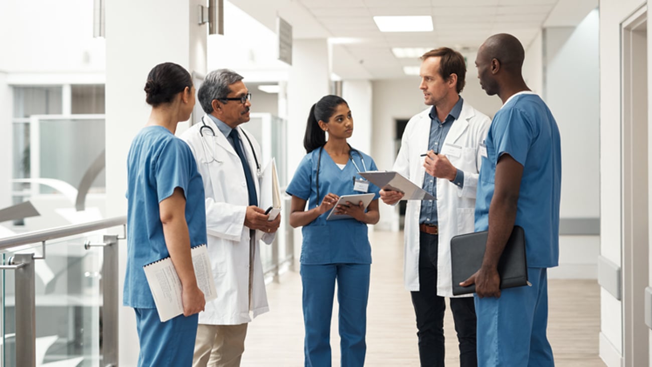 Des médecins et des résidents discutent dans un corridor.