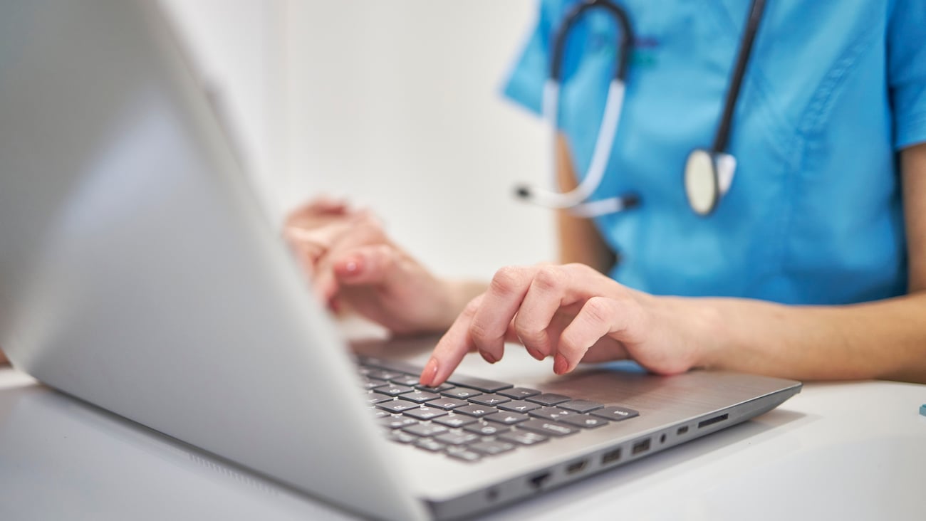 Médecin en train de taper sur le clavier de son ordinateur