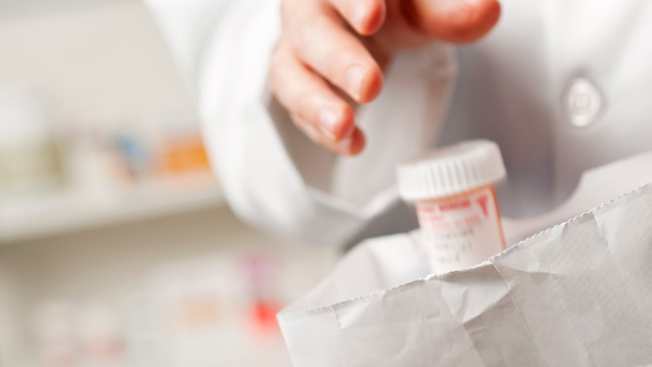 Médicament mis dans un sac par un pharmacien