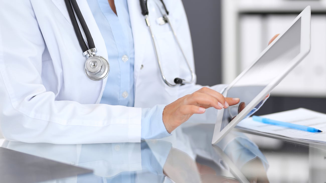 Gros plan sur les mains d'une femme médecin se servant d'une tablette