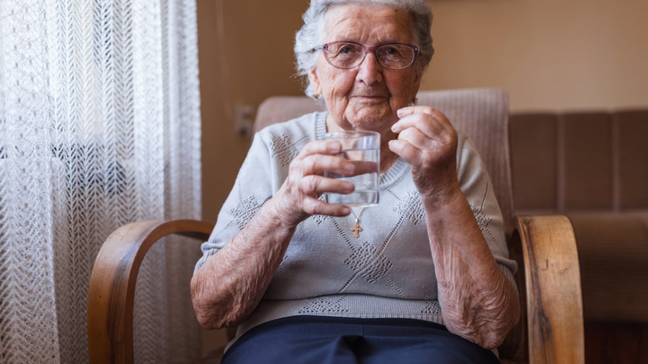 Une femme âgée prend un médicament