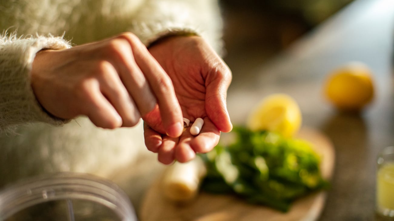 Une personne prend des compléments alimentaires