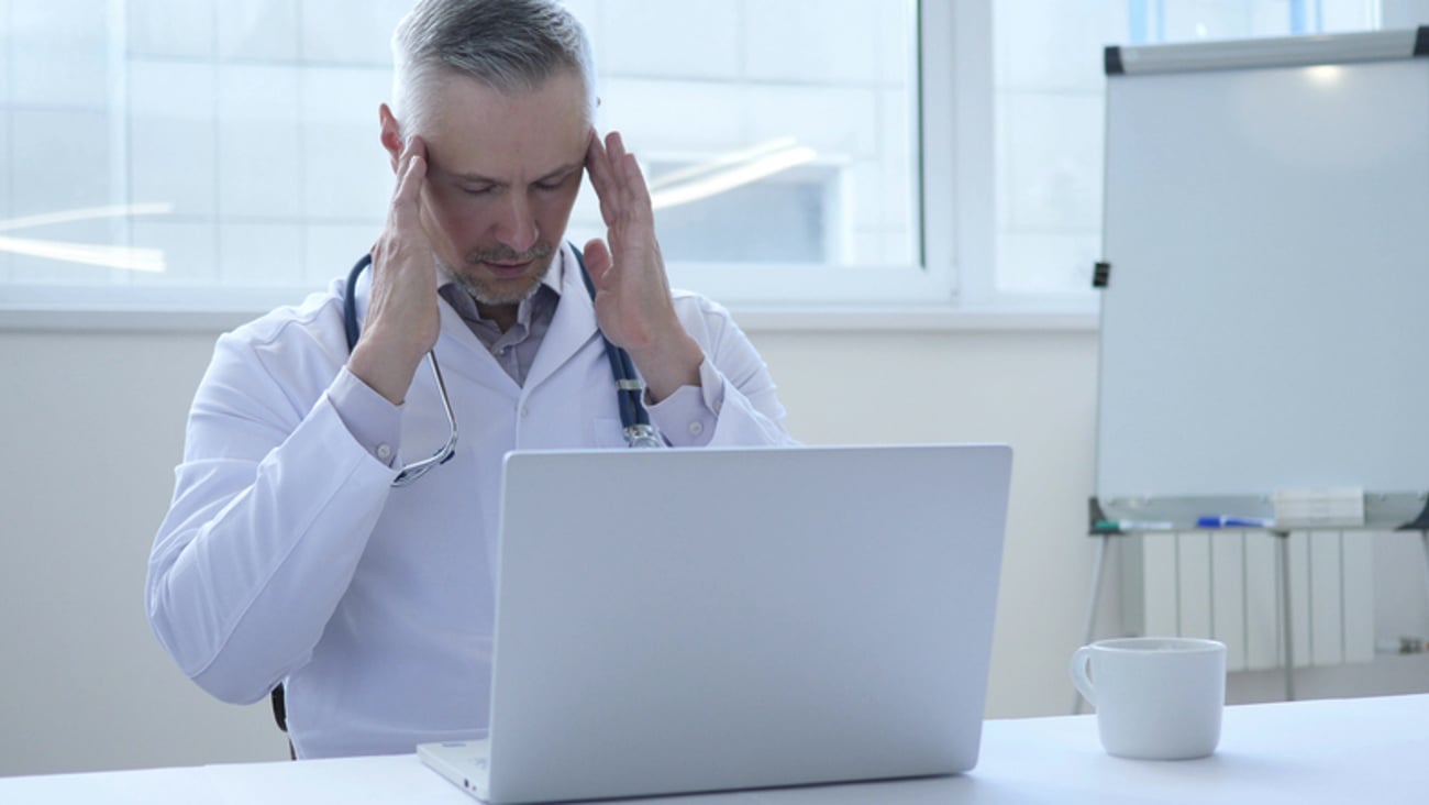 Médecin qui perd patience devant son ordinateur