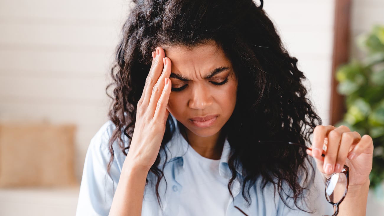 Coloured woman holding her head in pain
