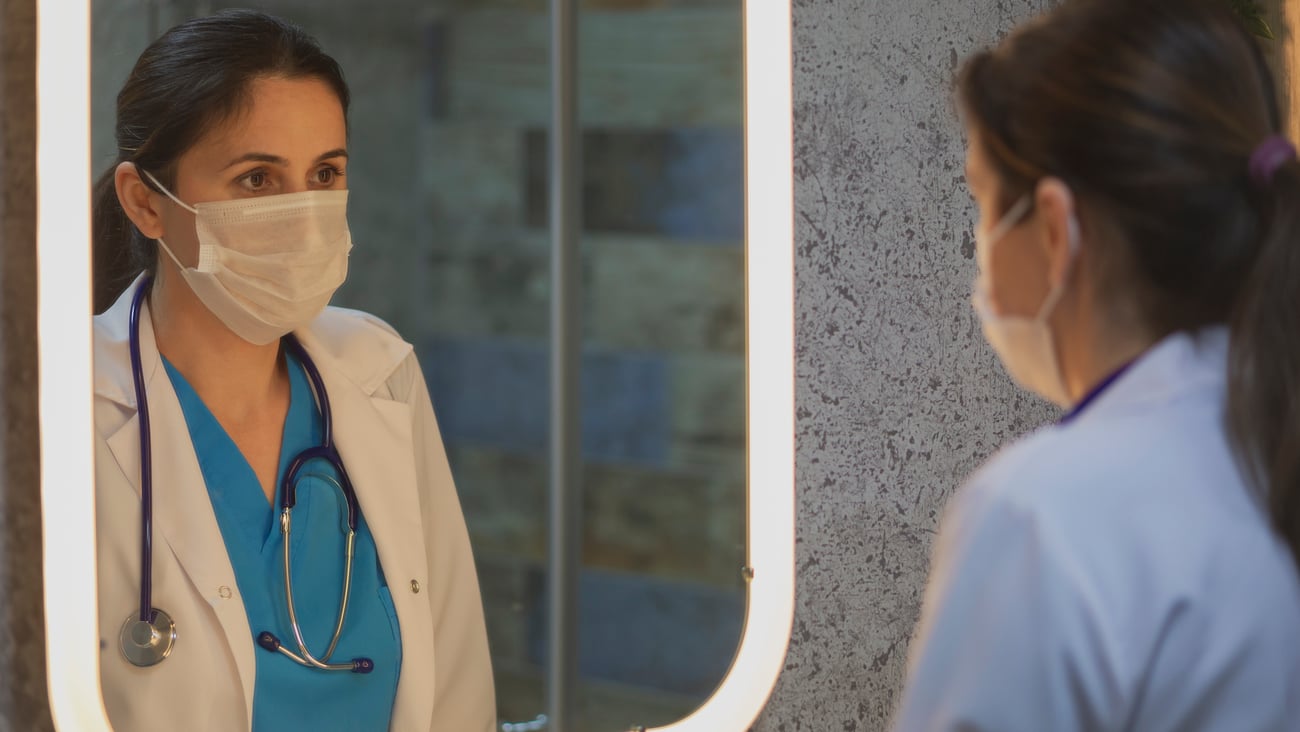 Médecin qui se regarde dans un miroir