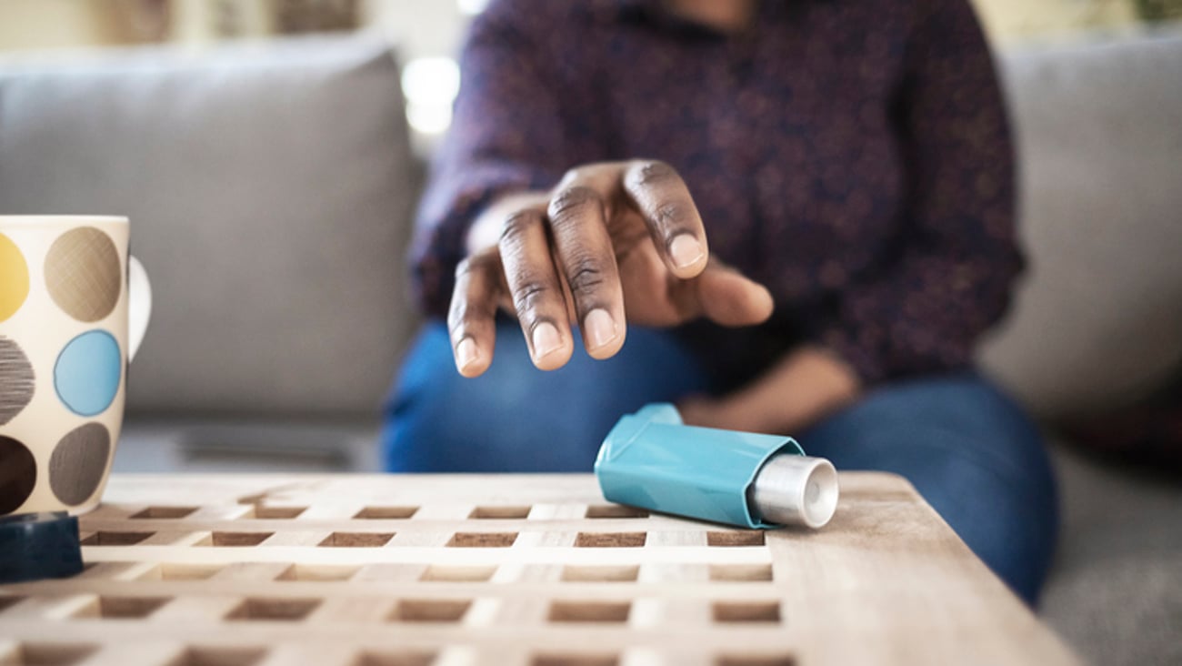 Une personne tend la main pour aller saisir sa pompe pour son asthme.