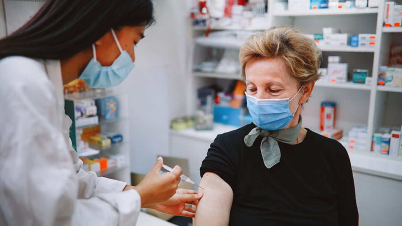 Une femme âgée se fait vacciner en pharmacie