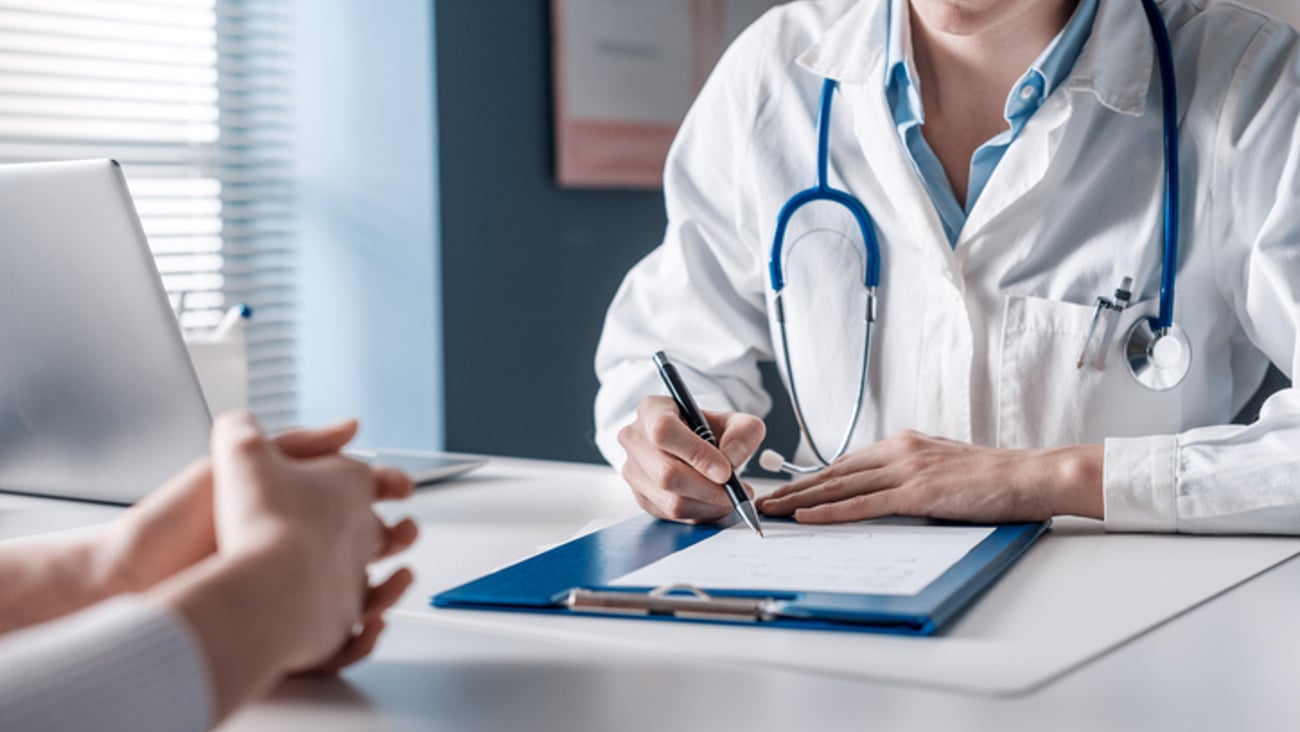 Une médecin écrit un certificat pour son patient