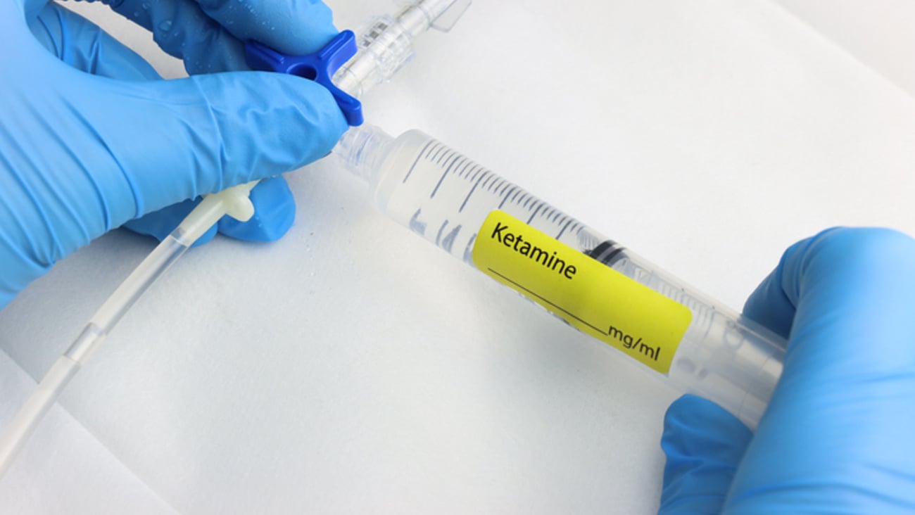 Un profesionnel de la santé dose de la kétamine dans un tube.