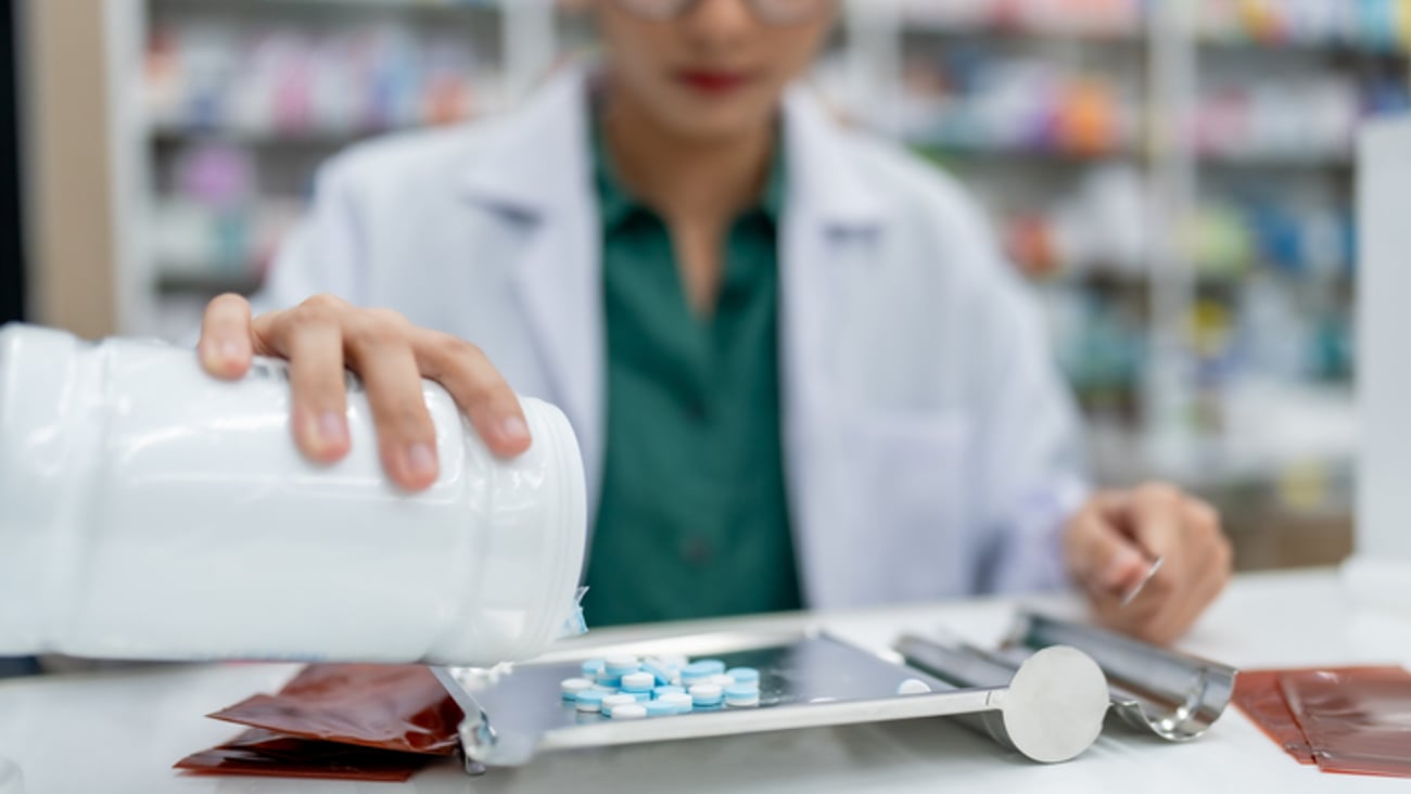Une pharmacienne manipule des médicaments dans un laboratoire.