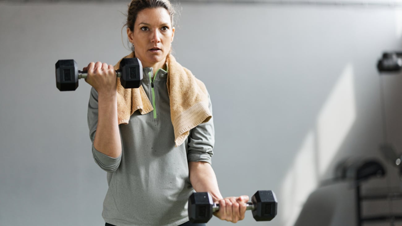 Une jeune femme soulève des poids lors d'un entraînement de musculation