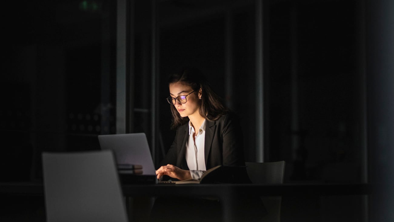 Une femme travaille dans un bureau, la nuit.