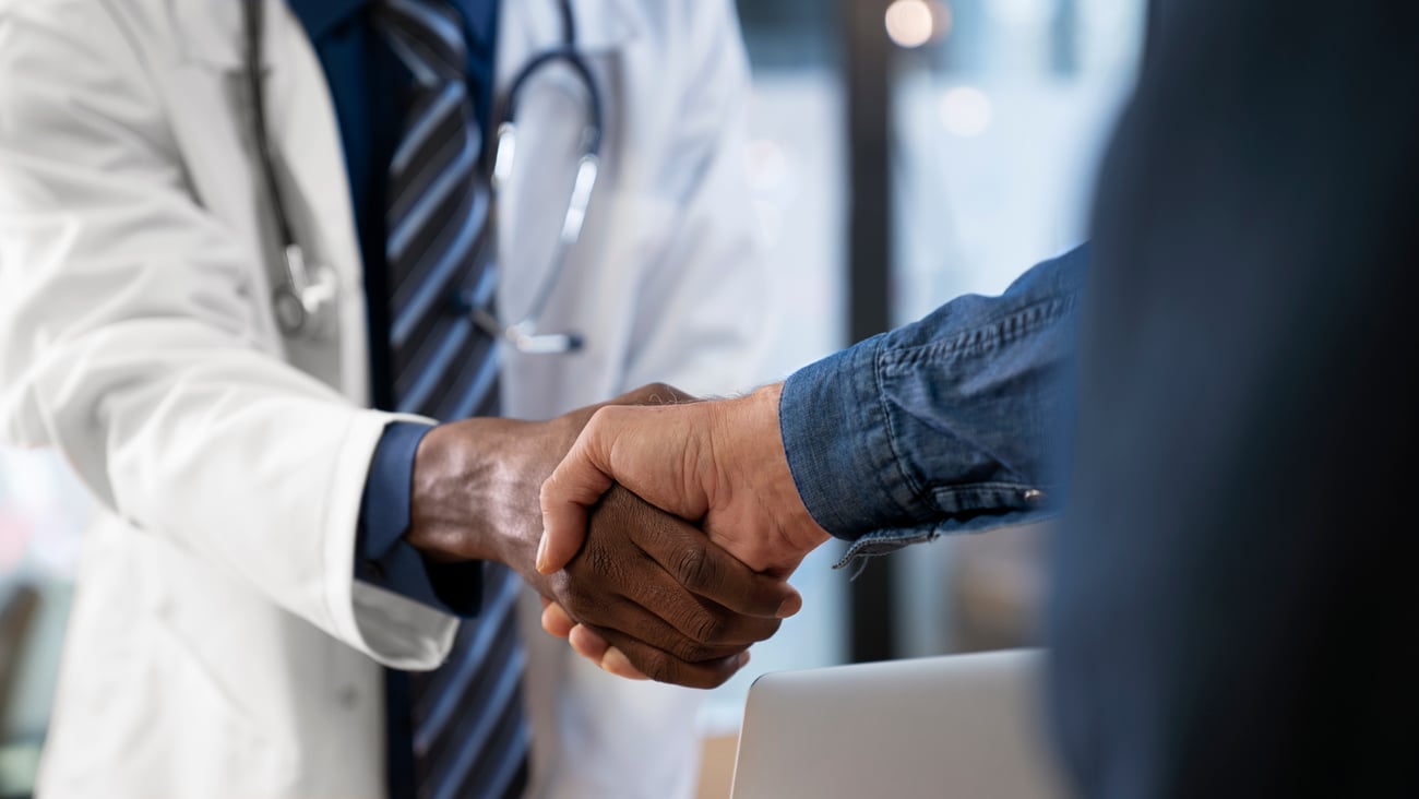Un médecin et un patient se serrent la main