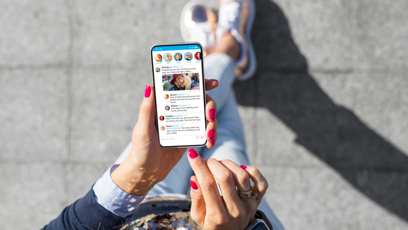 Une femme utilise son téléphone pour consulter des réseaux sociaux.