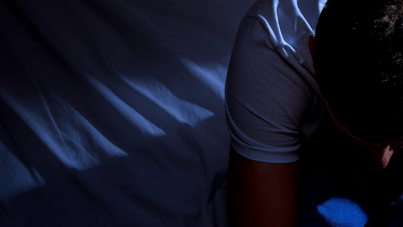 Homme assis éveillé dans son lit