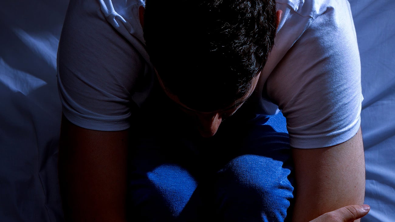 Homme assis éveillé dans son lit