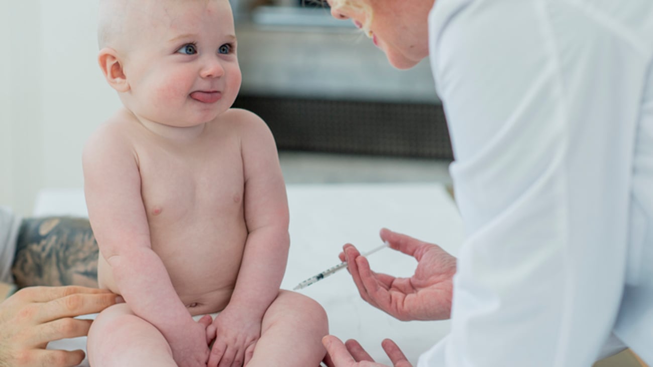 Une médecin ou une infirmière vaccine un bébé dans la cuisse.