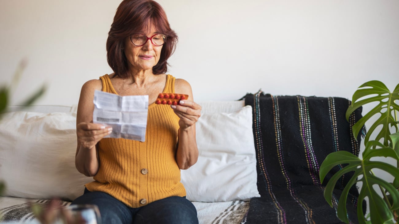 Une femme consulte les indications d'un traitement hormonal pour la ménopause.