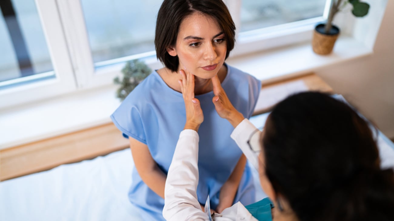 Une clinicienne examine la gorge d'une patiente possiblement atteinte d'une pharyngite au streptocoque.