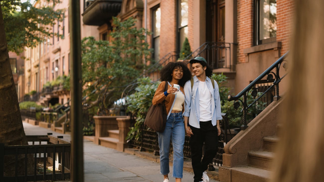 Un jeune couple marche avec contentement dans une rue de Brooklyn.