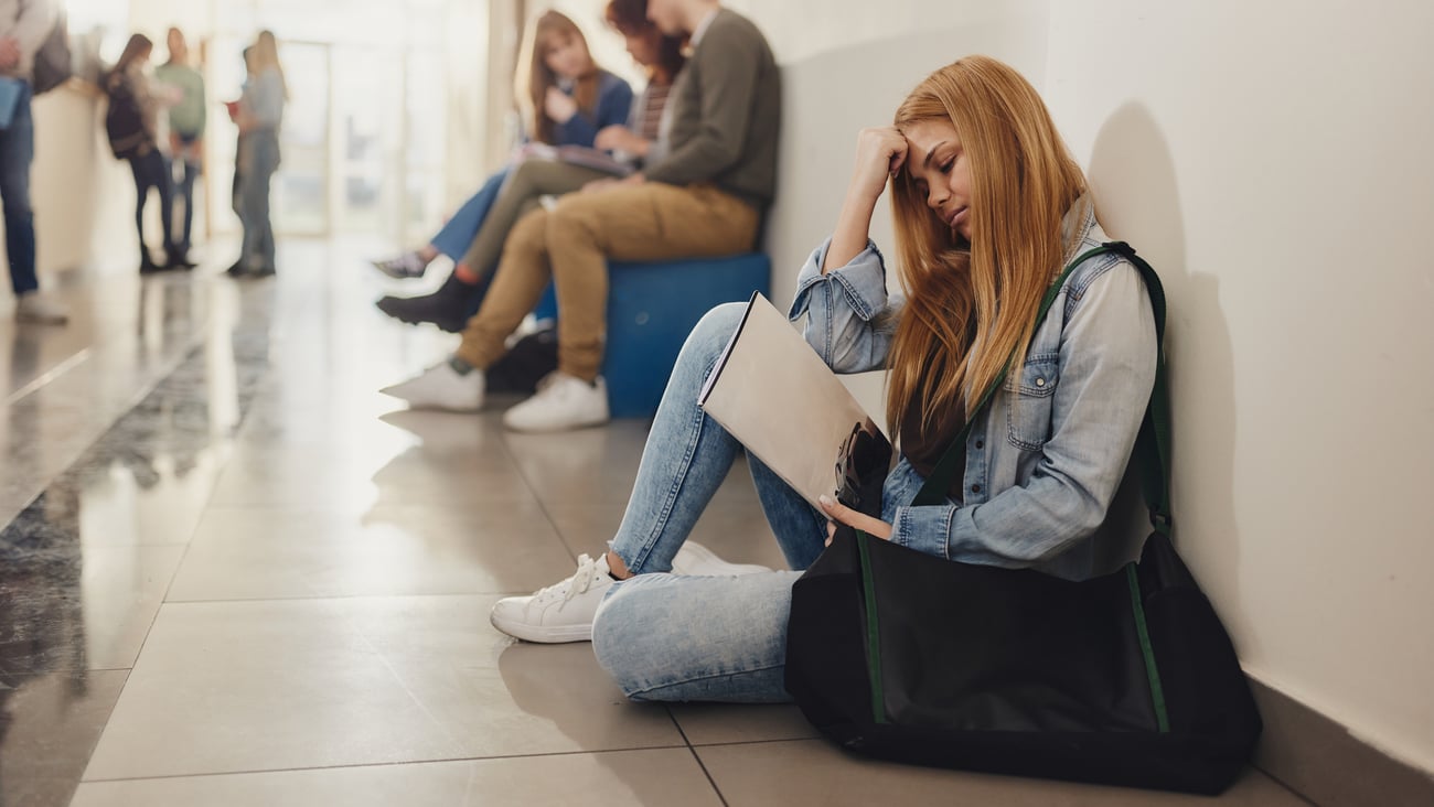Adolescente triste dans un couloir de son école. Crédit photo: skynesher/ Getty Images