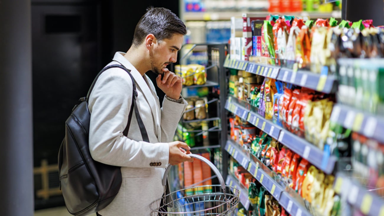 Un consommateur est en réflexion dans une épicerie.