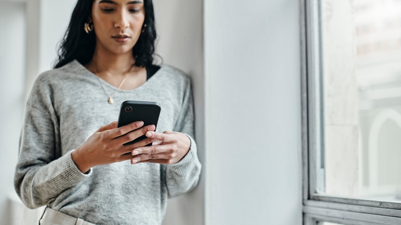 Une femme regarde son téléphone. Crédit photo: Delmaine Donson/Getty Images