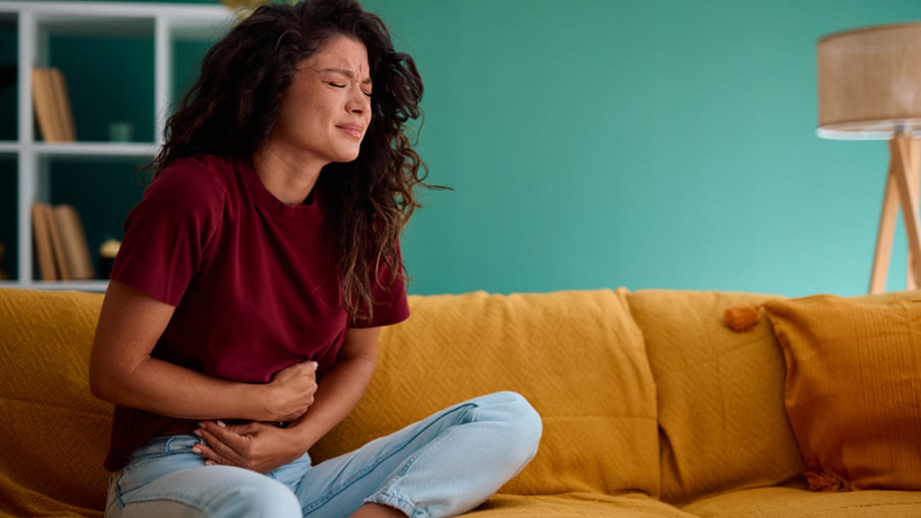 Une femme a d'intenses crampes au ventre, de la douleur abdominale.