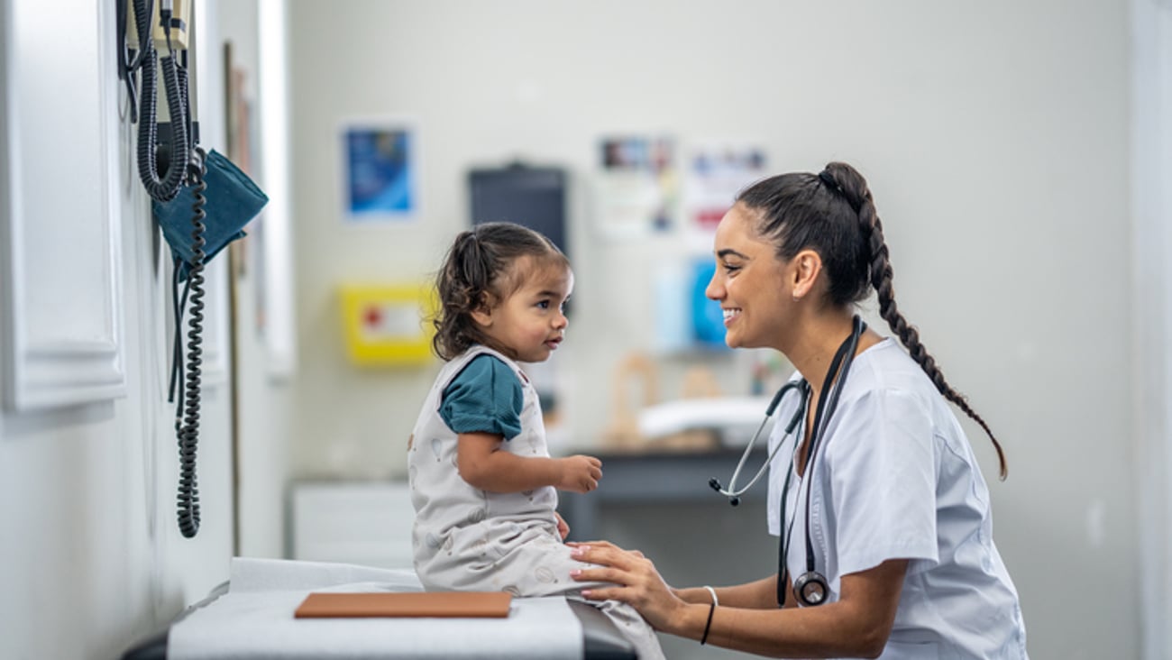 Une jeune enfant est en consultation avec une médecin ou une infirmière dans une clinique.