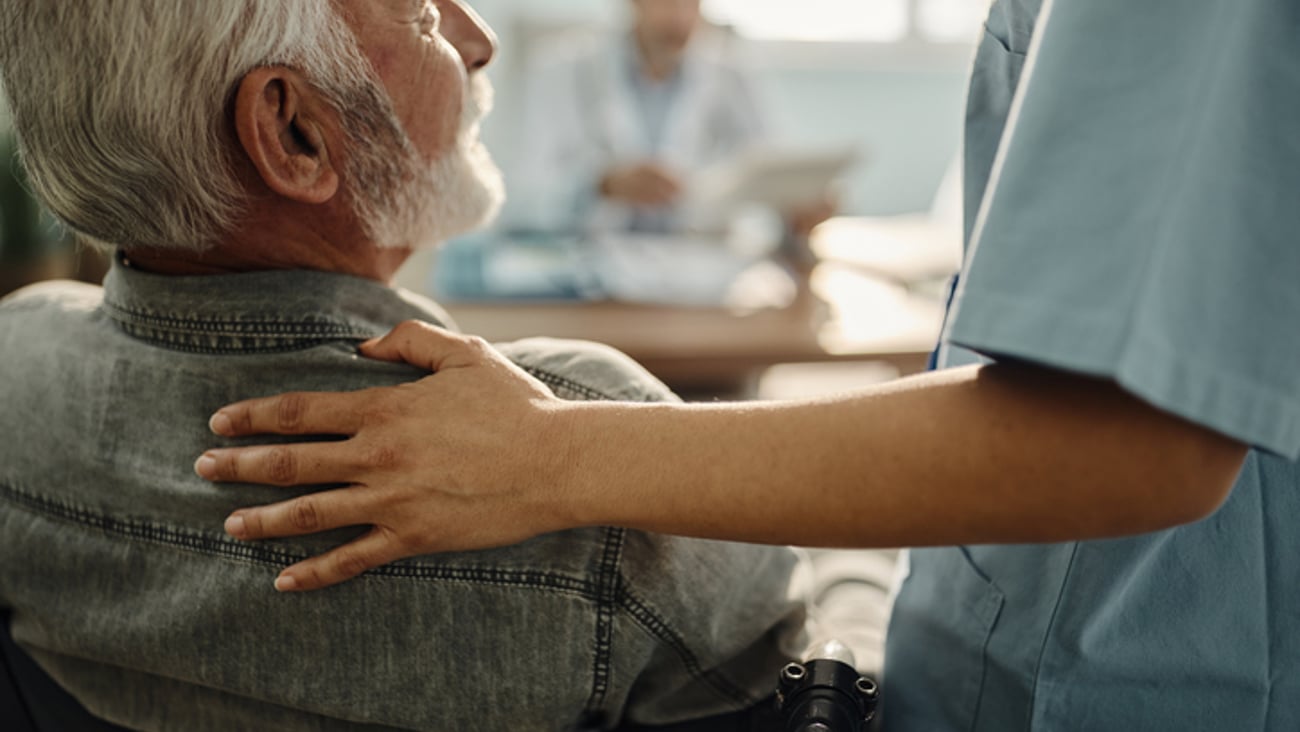 Une professionnelle de la santé fait preuve de compassion et d'empathie envers son patient âgé.