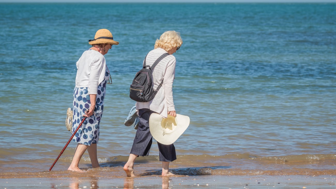 Personnes âgées se promenant au bord de l'eau par temps chaud