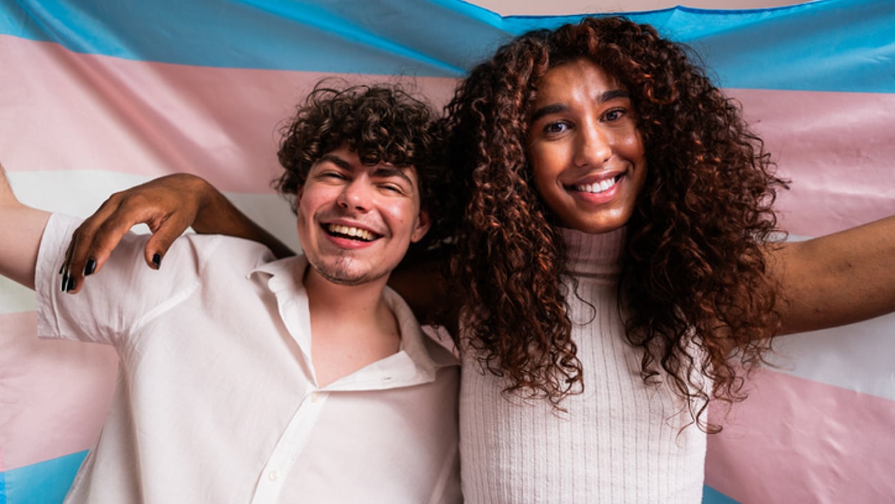 Deux jeunes personnes transgenres tenant un drapeau