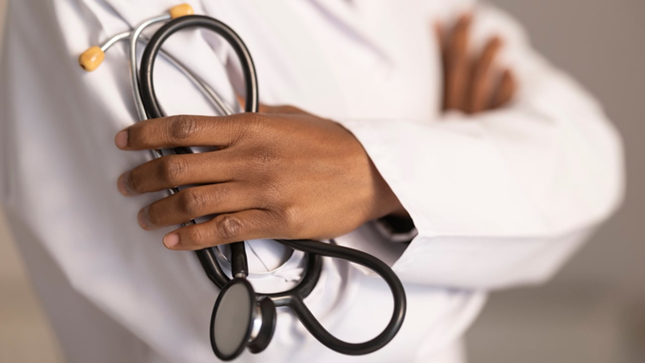 Un médecin tient un stéthoscope en ayant les bras croisés.