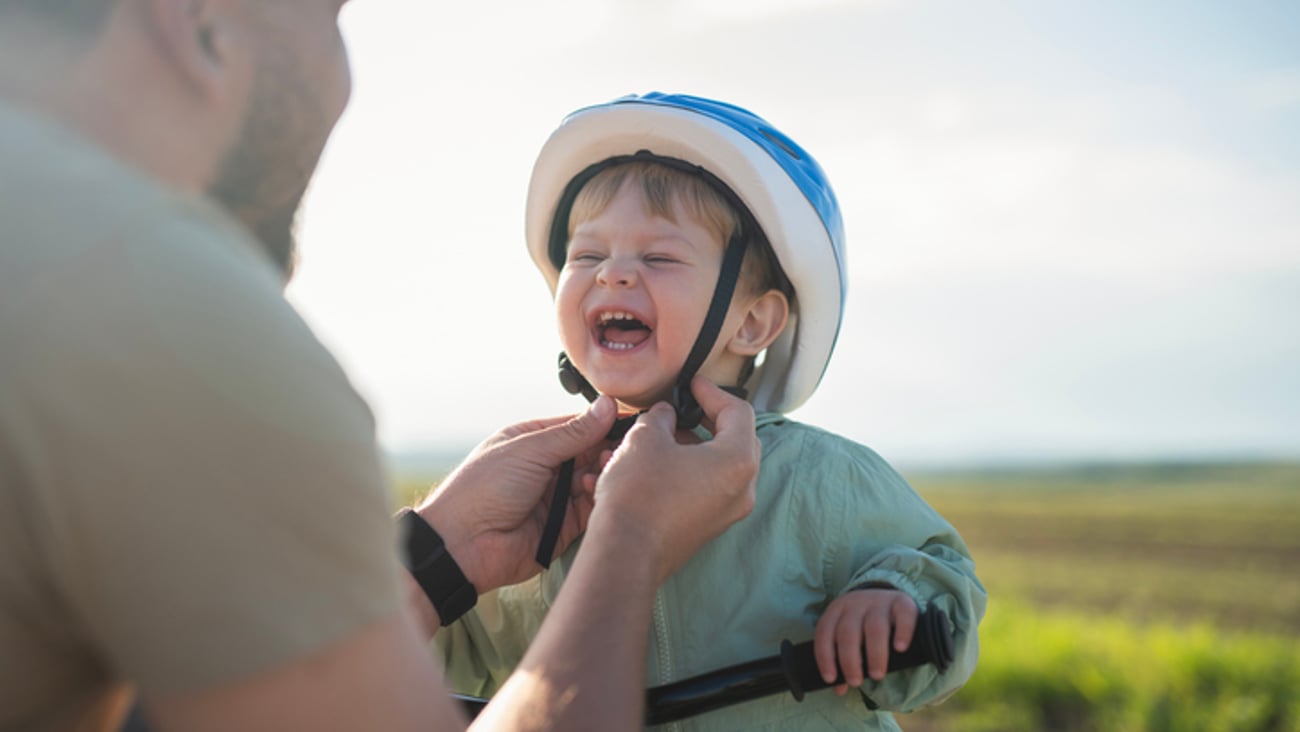 Un parent met un casque de vélo à son enfant