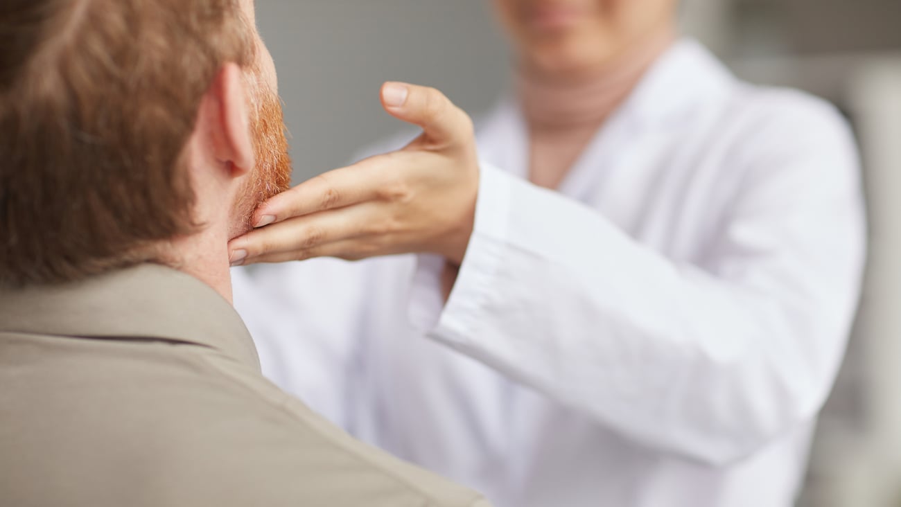 Médecin qui palpe le cou d'un patient