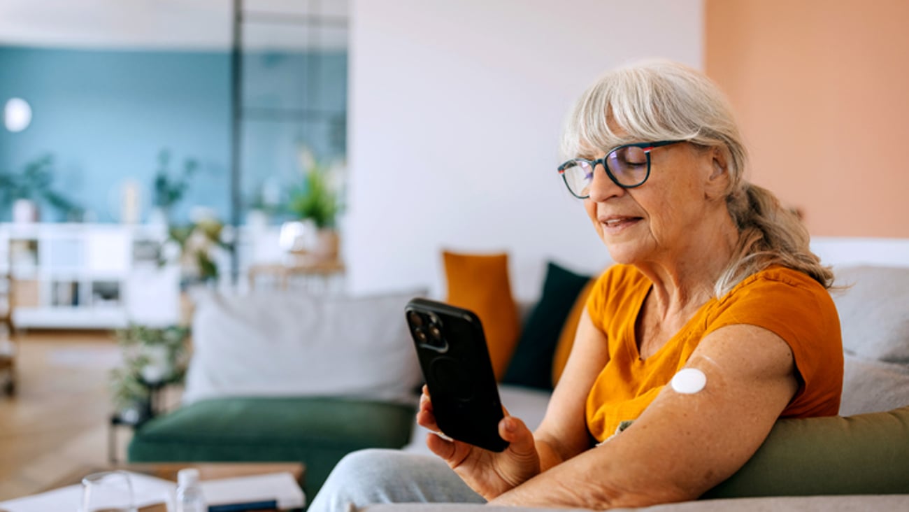 Une aîné surveille son diabète avec son téléphone.