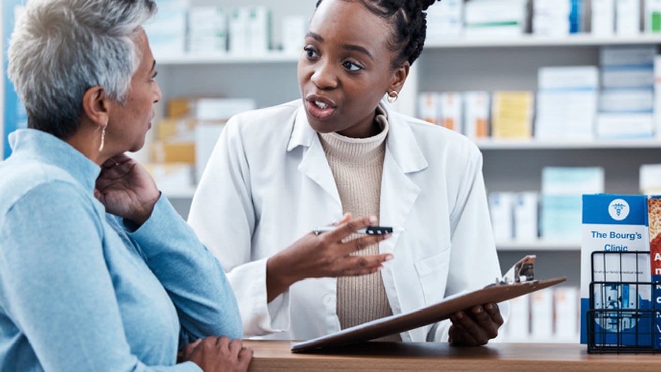 Une pharmacienne noire discute avec une patiente âgée