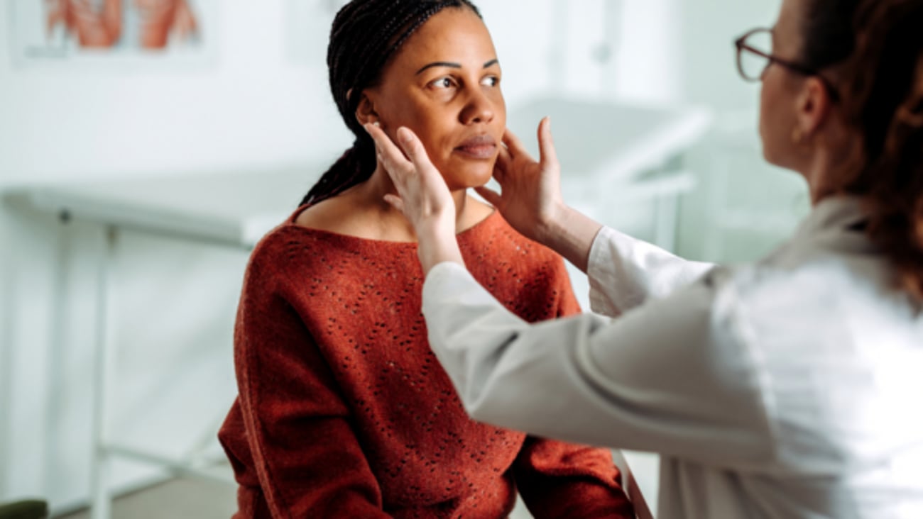 Une femme médecin fait une consultation physique dans son cabinet.