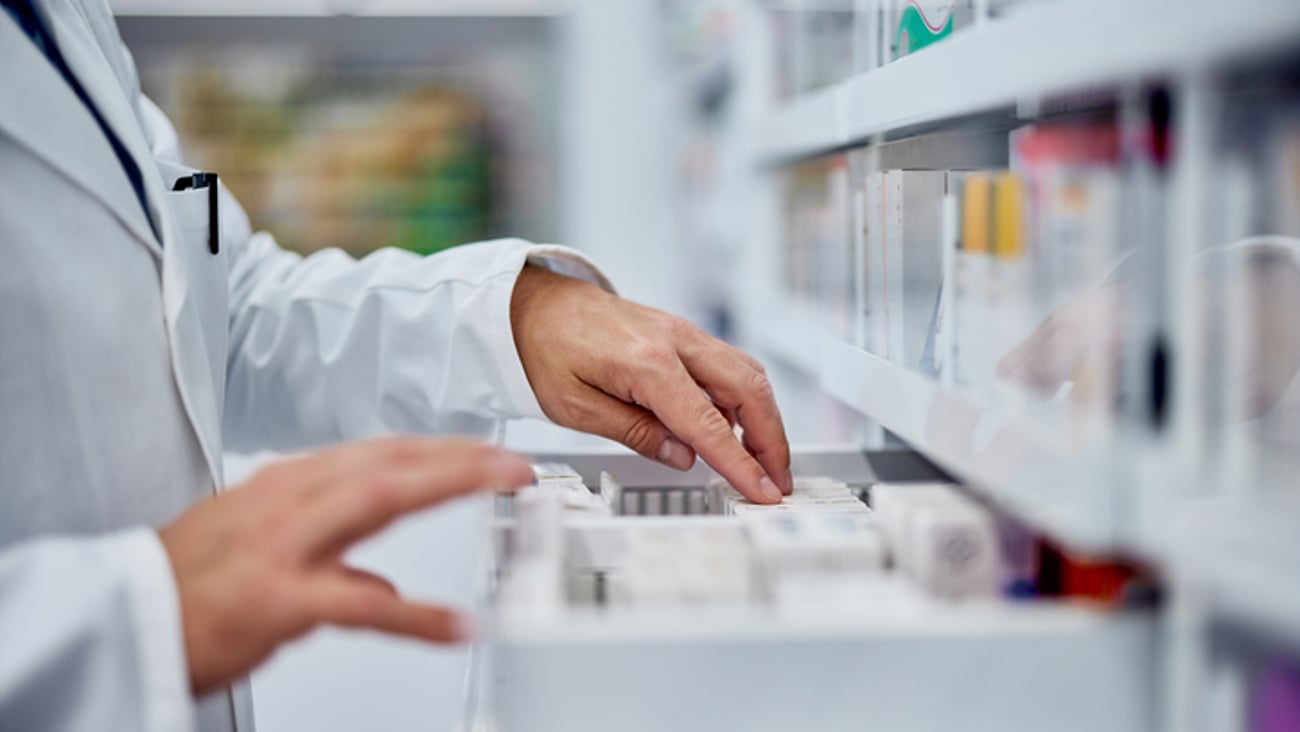 Les mains d'une pharmacienne en train de ranger des médicaments