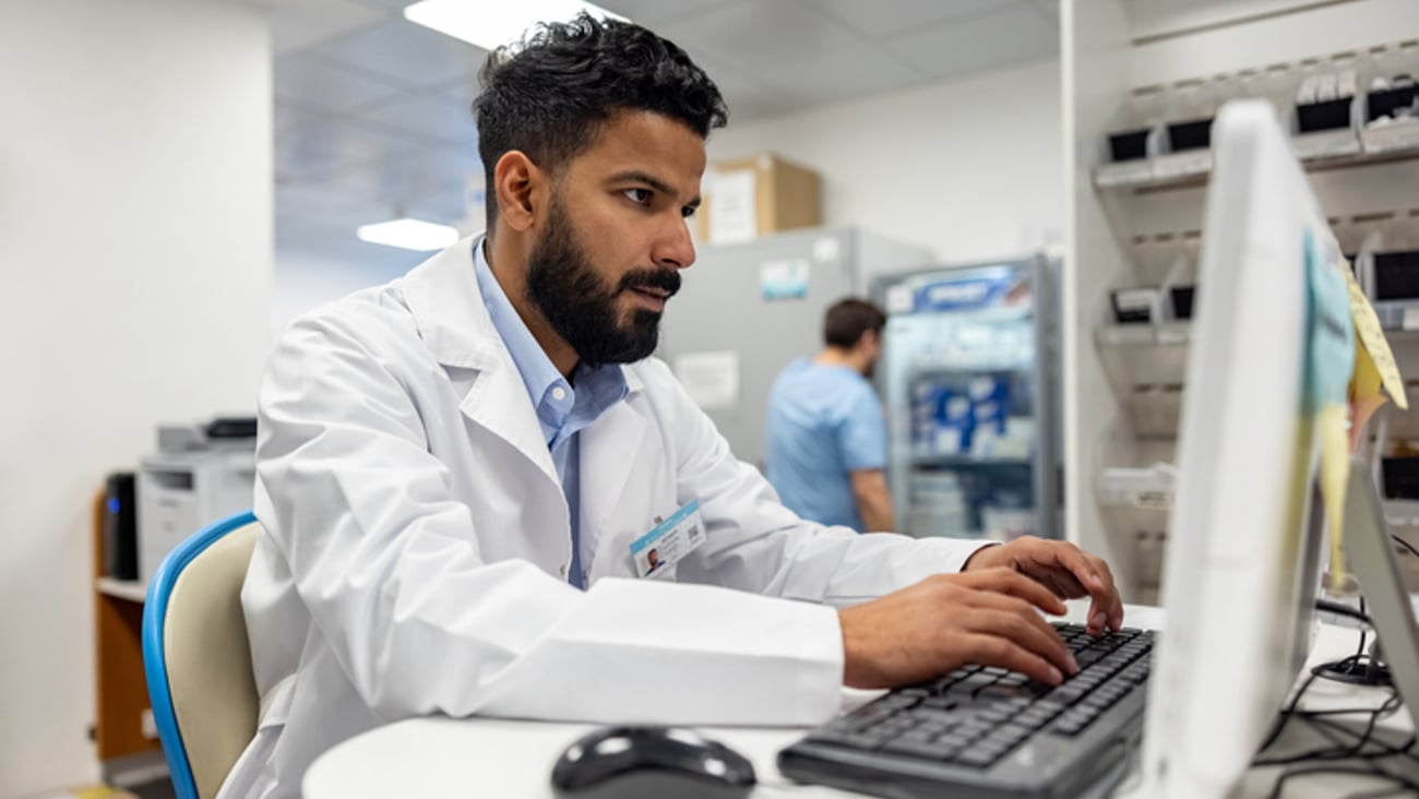 Un jeune pharmacien tape à l'ordinateur