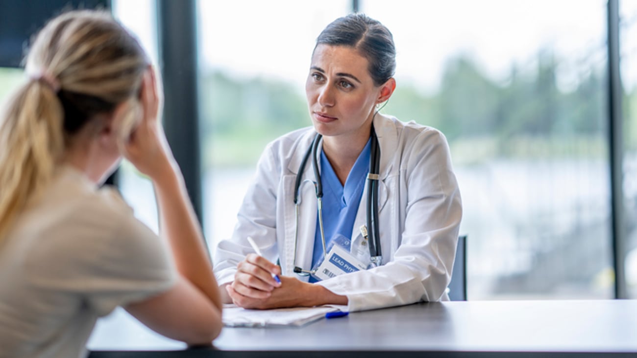 Une médecin annonce une mauvaise nouvelle à sa patiente lors d'une consultation.