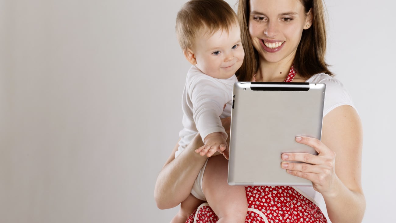 Young mother is looking at tablet with her baby; Shutterstock ID 136065596